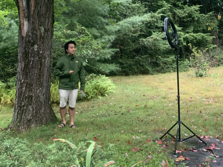Albert Kim next to a tree and in front of a recording device